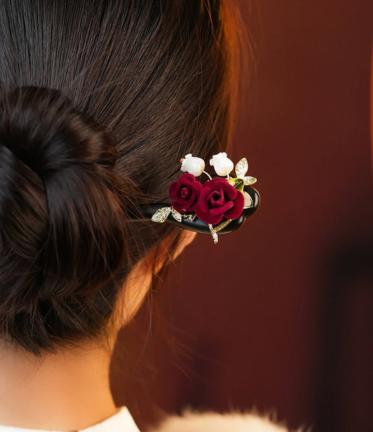 Bride wearing elegant red rose wooden hair stick in a wedding updo