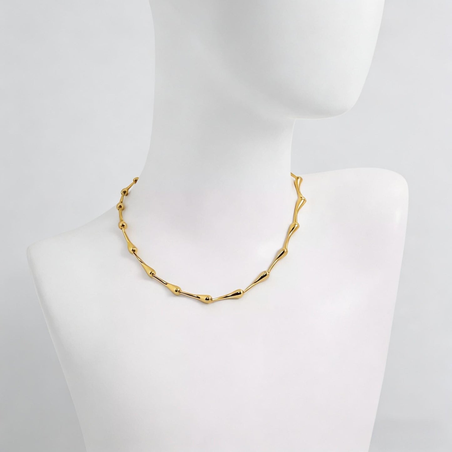 Gold bamboo water drop necklace on a mannequin