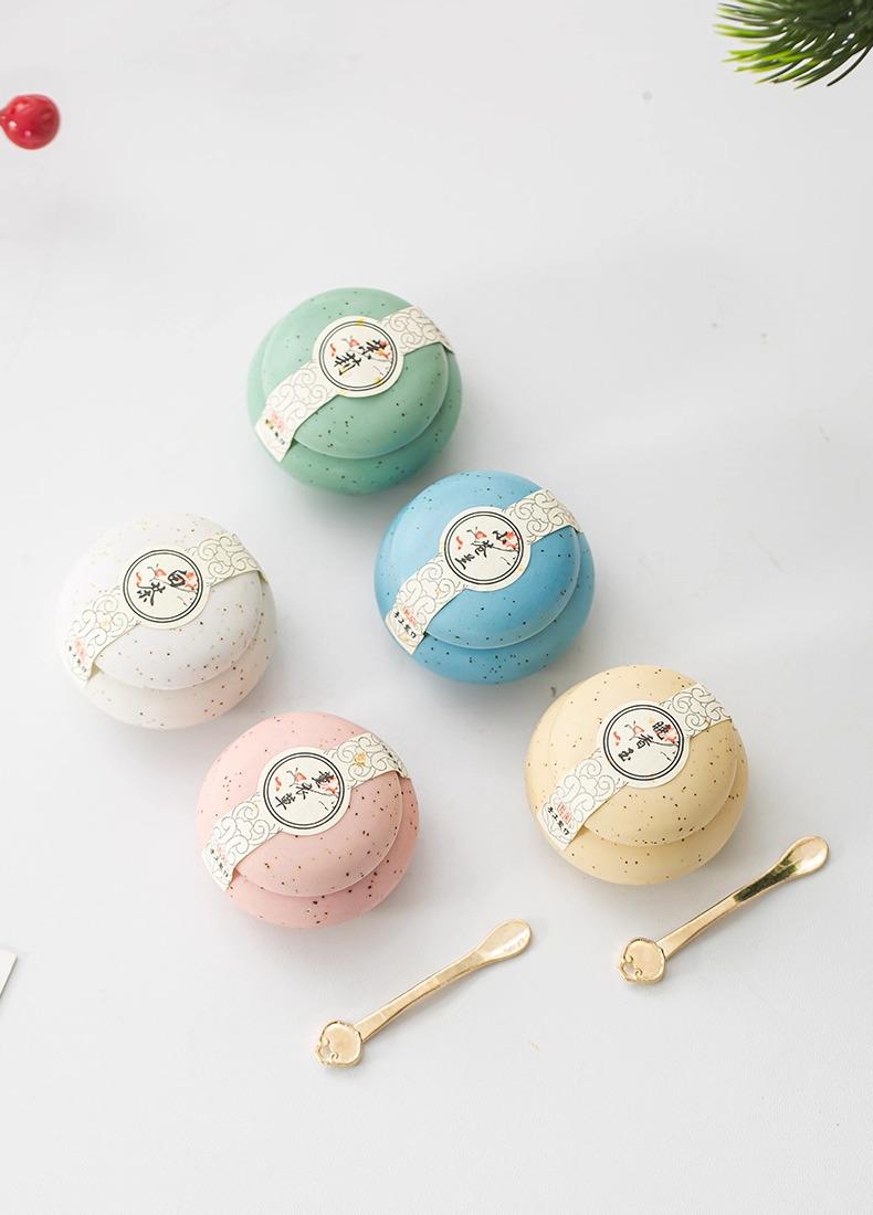 5 Solid Perfumes, Different scents with decorative labels on a light surface and 2 small spoons