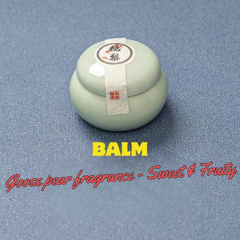 Balm container with a label on a blue background, featuring text about goose pear fragrance.