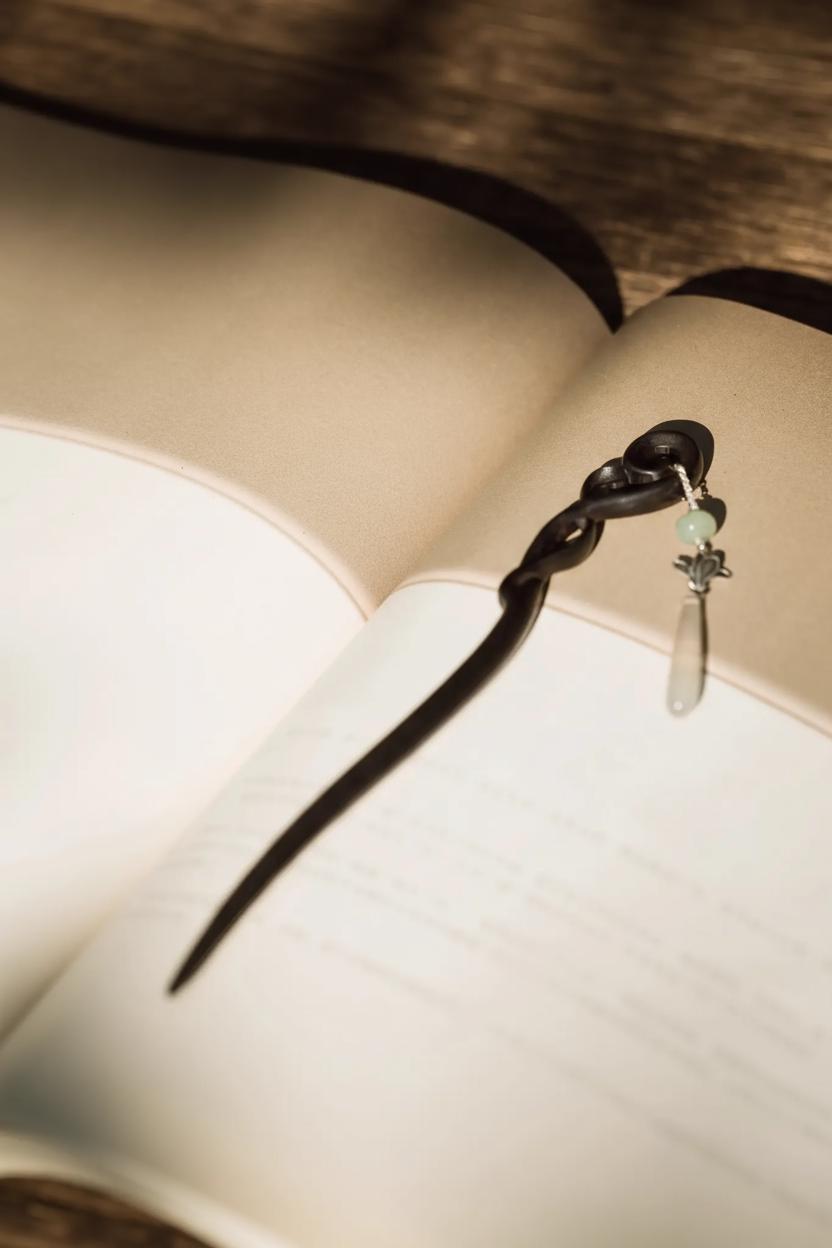 Black hair tie with a green bead on an open book