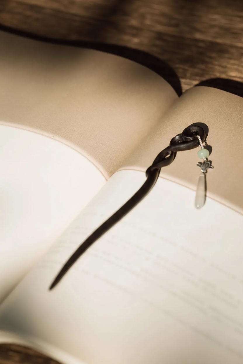 Black hair tie with a green bead on an open book