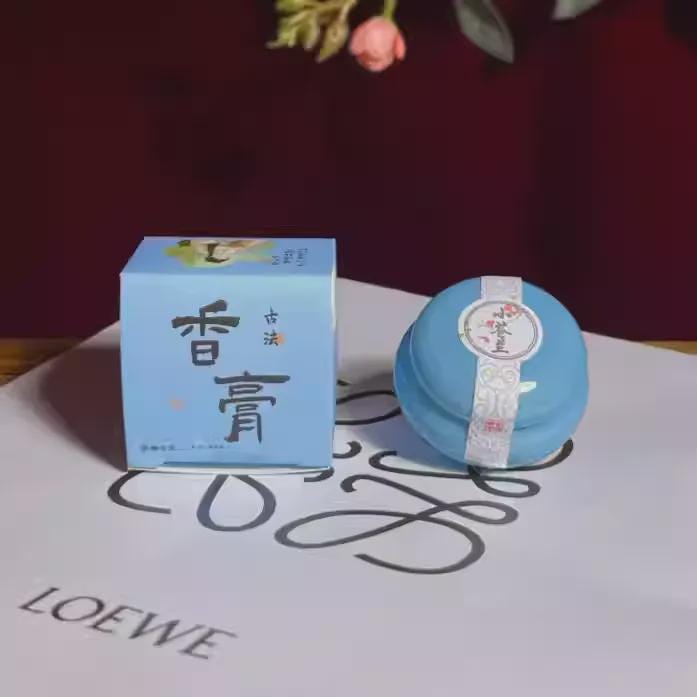 Blue balm with packaging on a white surface