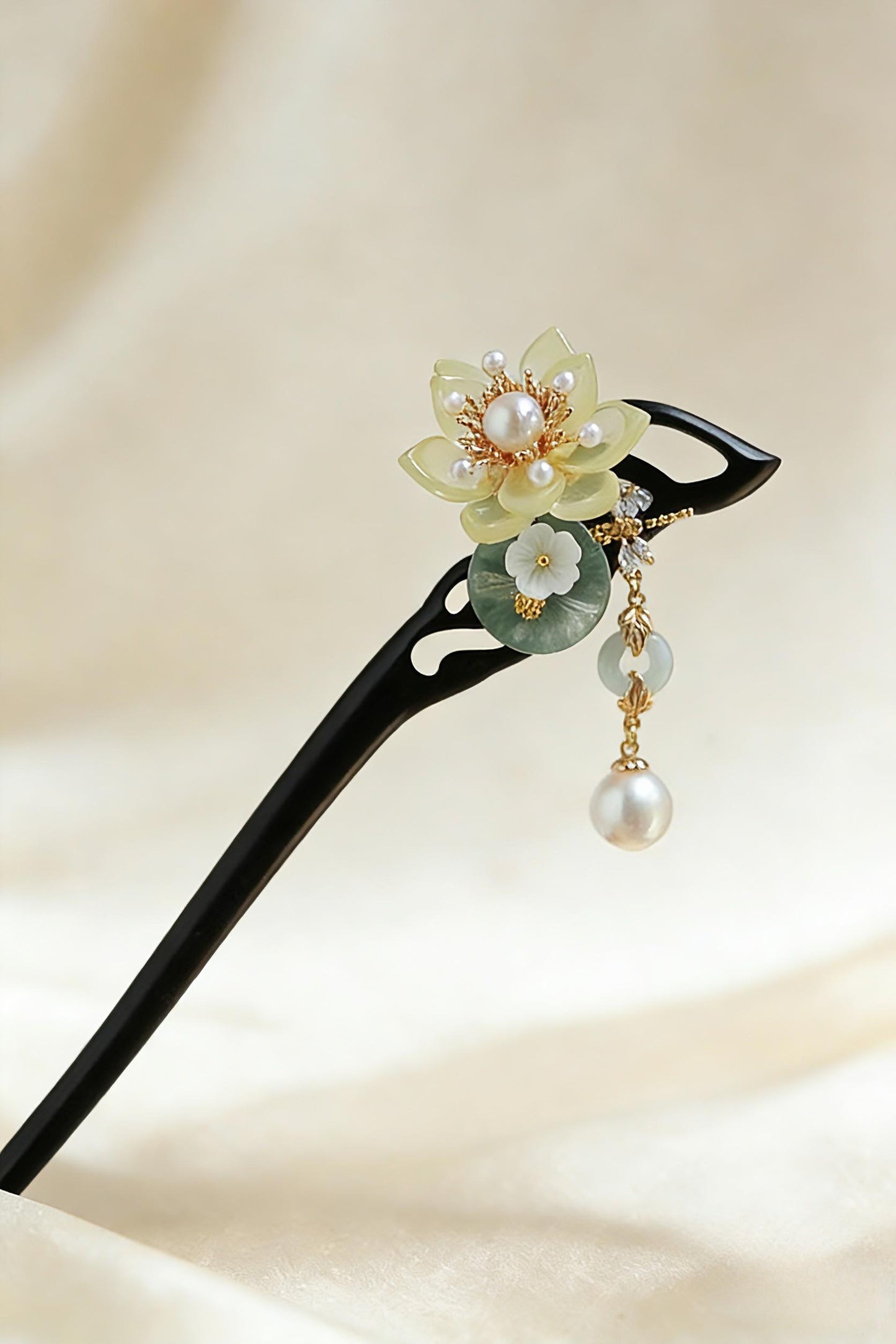 Decorative hairpin with floral design and pearls on a beige background