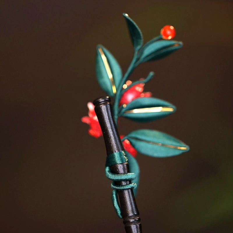 Close-up of traditional Chinese Chanhua (silk-wrapped flower) craftsmanship on a pomegranate hair pin.