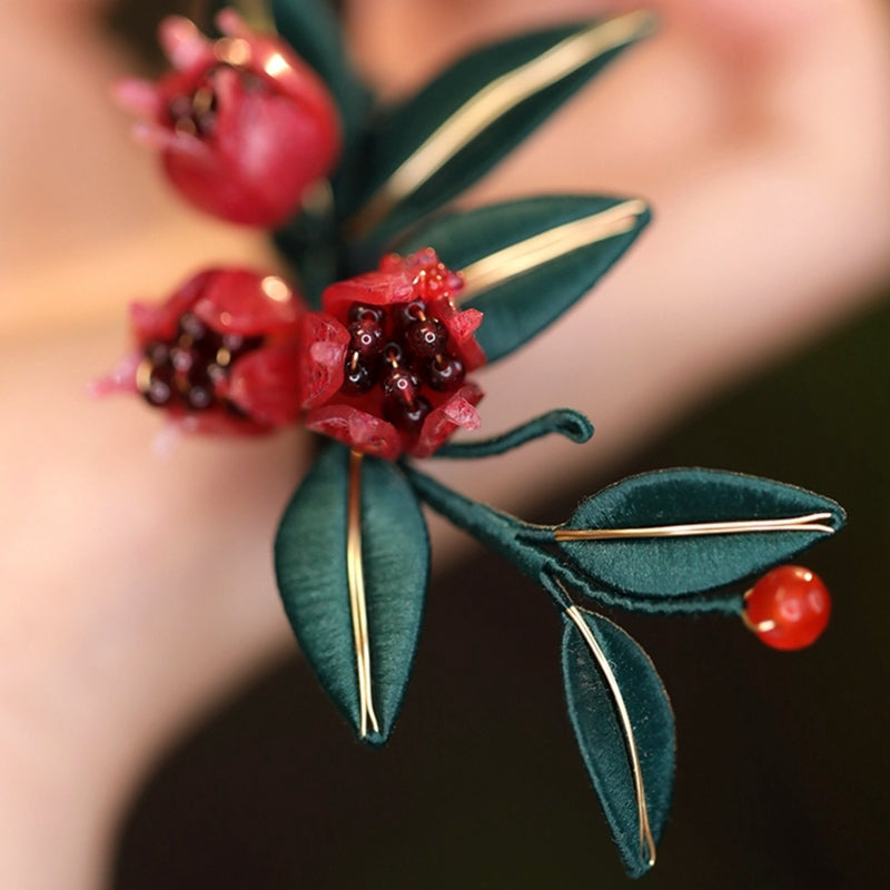 Close-up of traditional Chinese Chanhua (silk-wrapped flower) craftsmanship on a pomegranate hair pin
