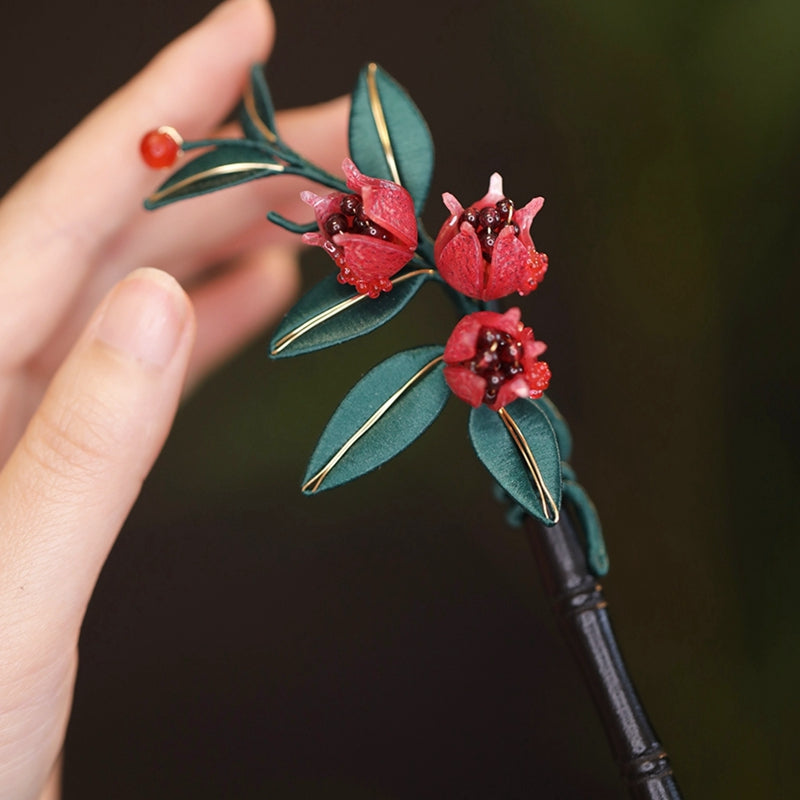 Close-up of traditional Chinese Chanhua (silk-wrapped flower) craftsmanship on a pomegranate hair stick