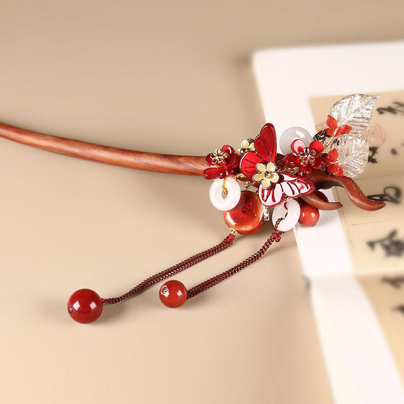 Close-up of traditional Chinese cloisonne and jade butterfly detail on a sandalwood hair pin.