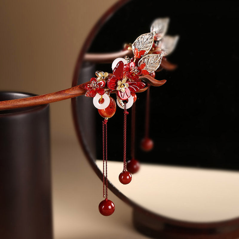 Close up of traditional Chinese cloisonne and jade butterfly detail on a sandalwood hair pin