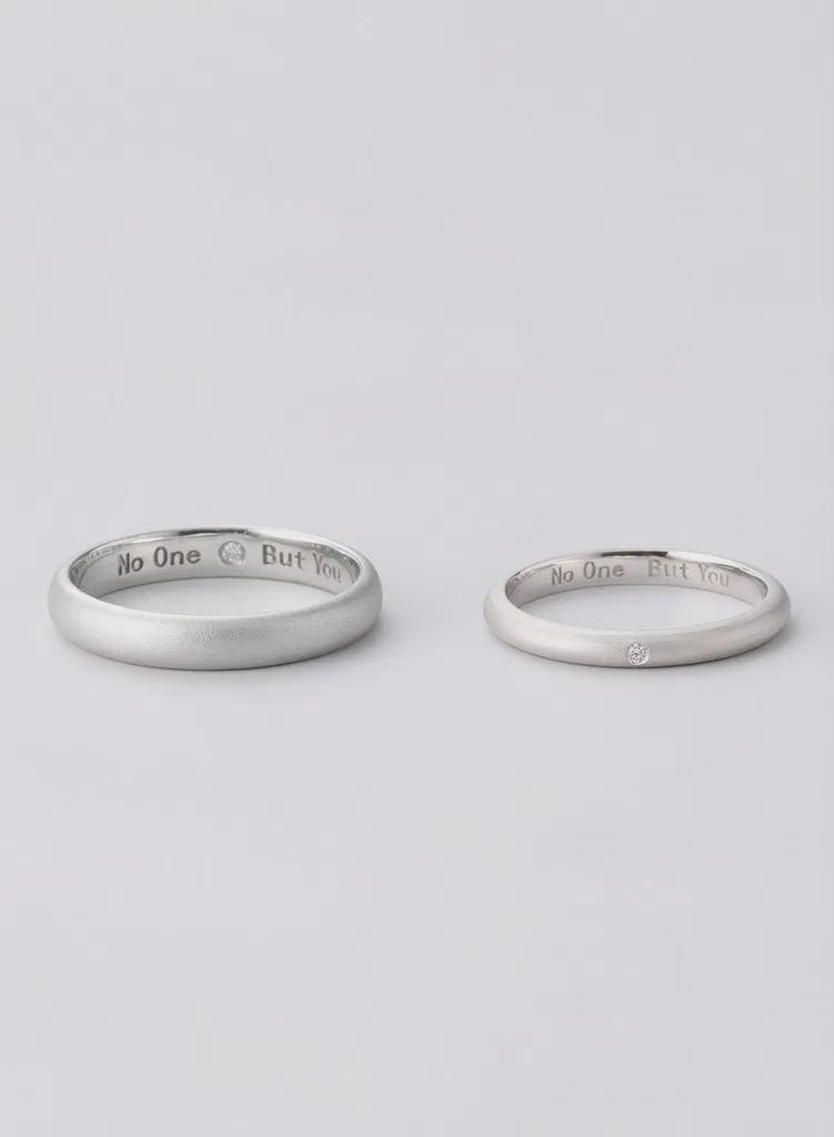Two silver rings with engraved text on a light gray background