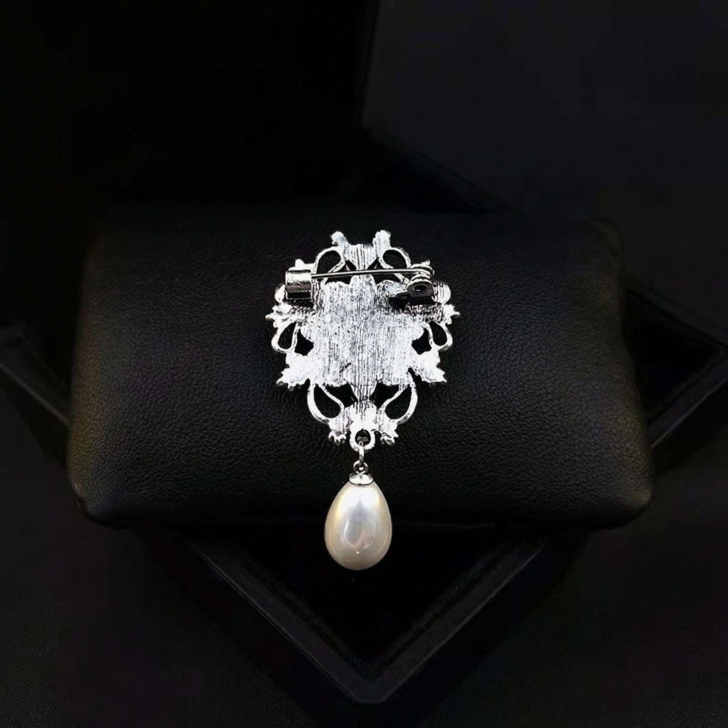 Decorative brooch with a pearl on a black background