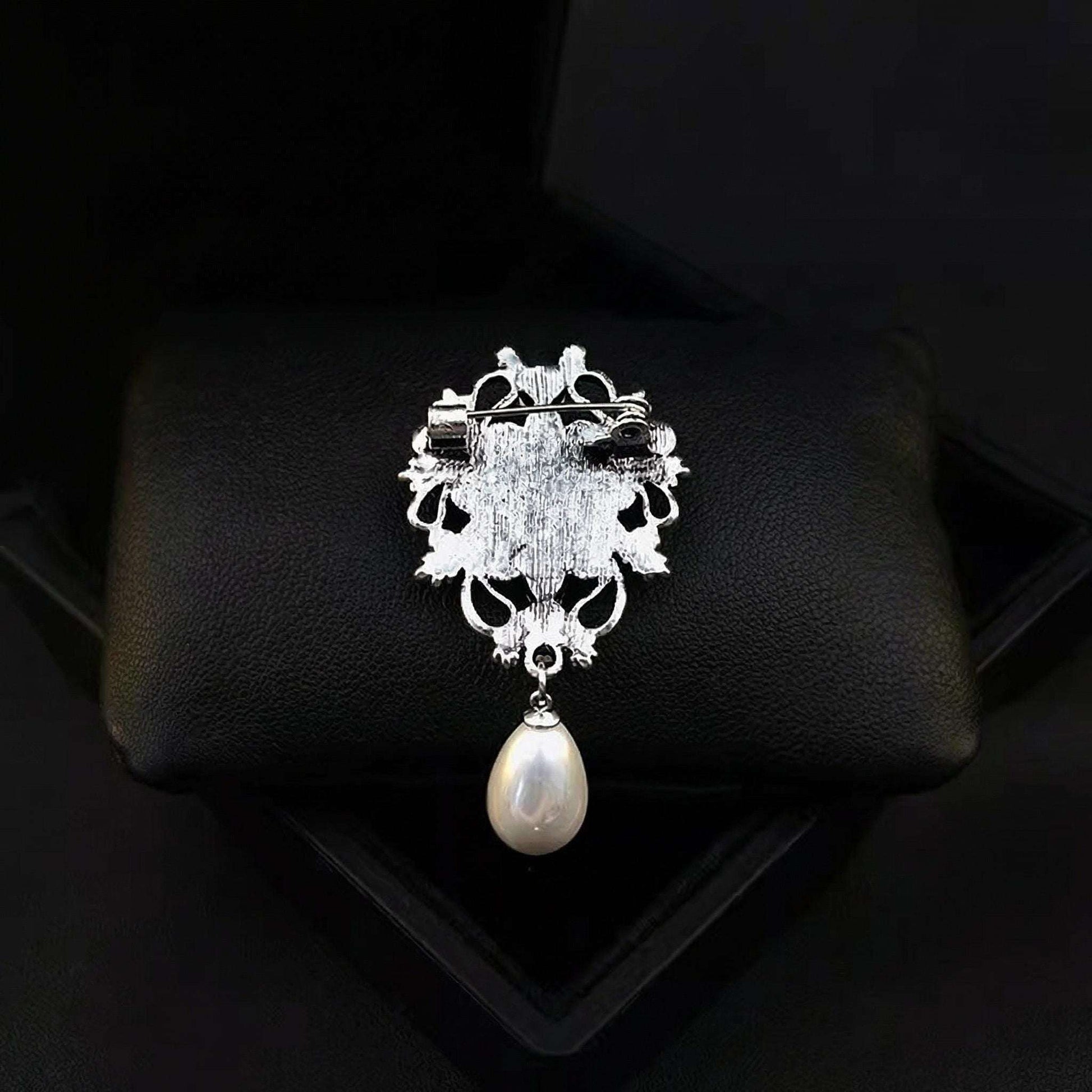 Decorative brooch with a pearl on a black background
