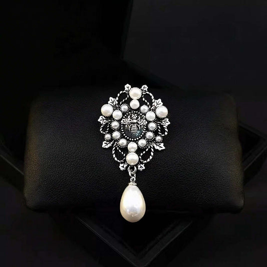 Decorative brooch with pearls on a black cushion