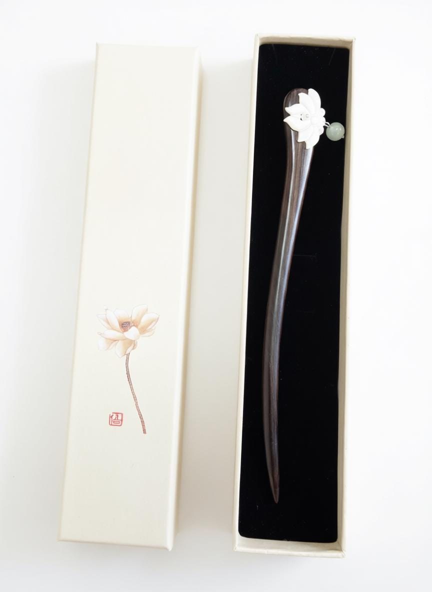 Decorative hairpin with floral design in a black box on a white background