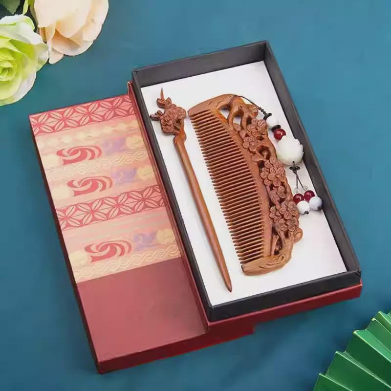 Decorative wooden comb and hairpin set in a gift box with floral background