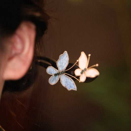 Detailed view of silk mesh butterfly wings and golden copper hair pin accessories