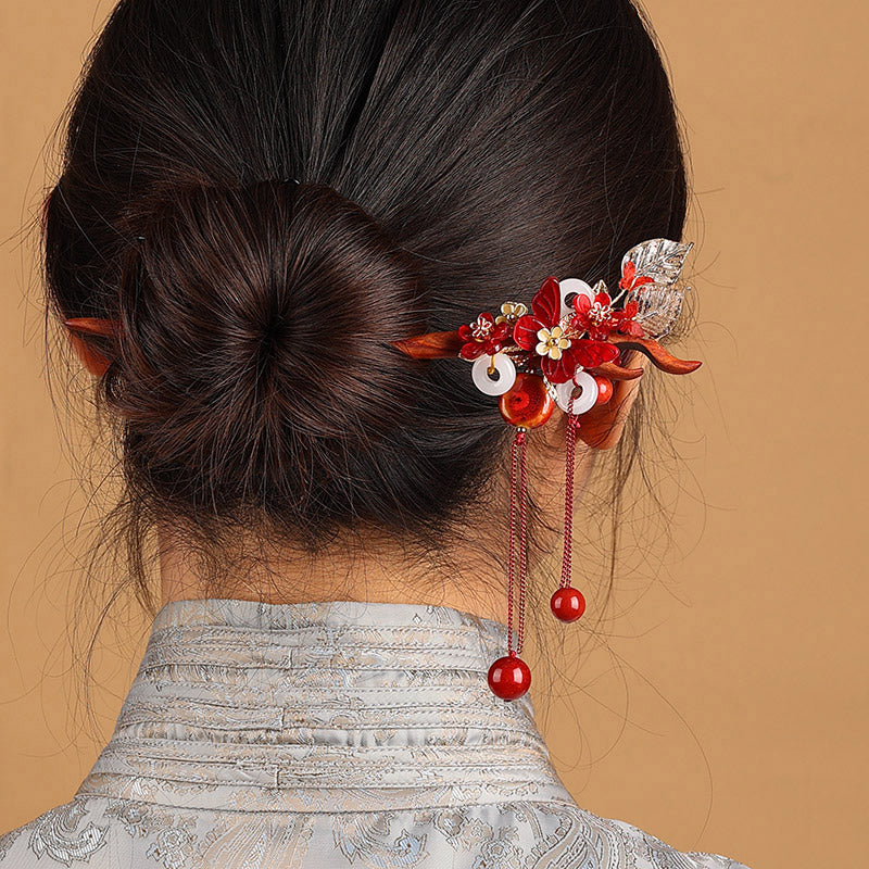 Elegant bride wearing a red sandalwood butterfly hairpin with traditional Chinese wedding attire.