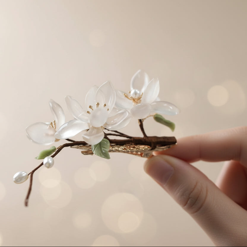 Floral hair accessory with white flowers and green leaves on a dark background