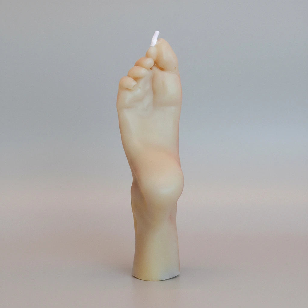 Candle shaped like a foot on a gradient background