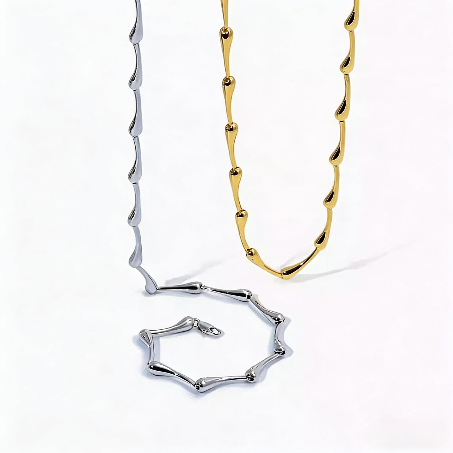 Gold and silver water drop necklaces on a white background