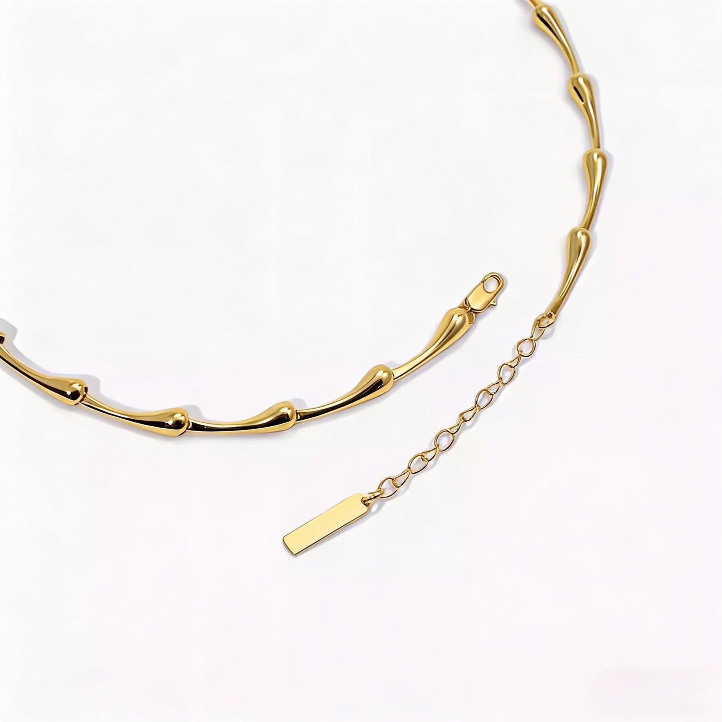 Gold necklace with a plain tag on a white background