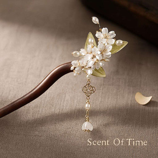 Hair pin with pearls and leaves on a textured surface, featuring 'Scent Of Time' branding.
