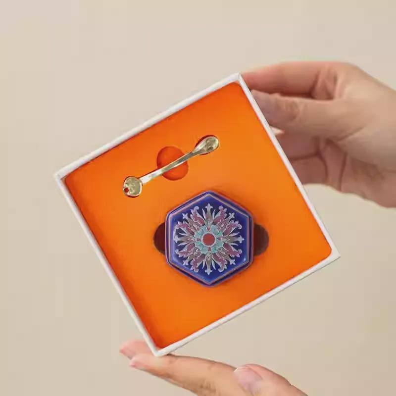 A Balm in an open box held by a hand