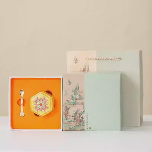 Set of Balms including a spoon, hexagonal ornament, and a box with artistic design on a light background.