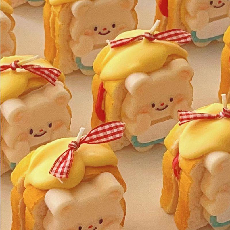 Cute bear-shaped cookies with yellow hair bows on a light background