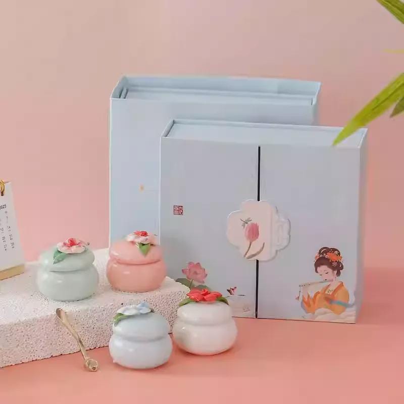 Set of small ceramic pots with floral designs on a pink background