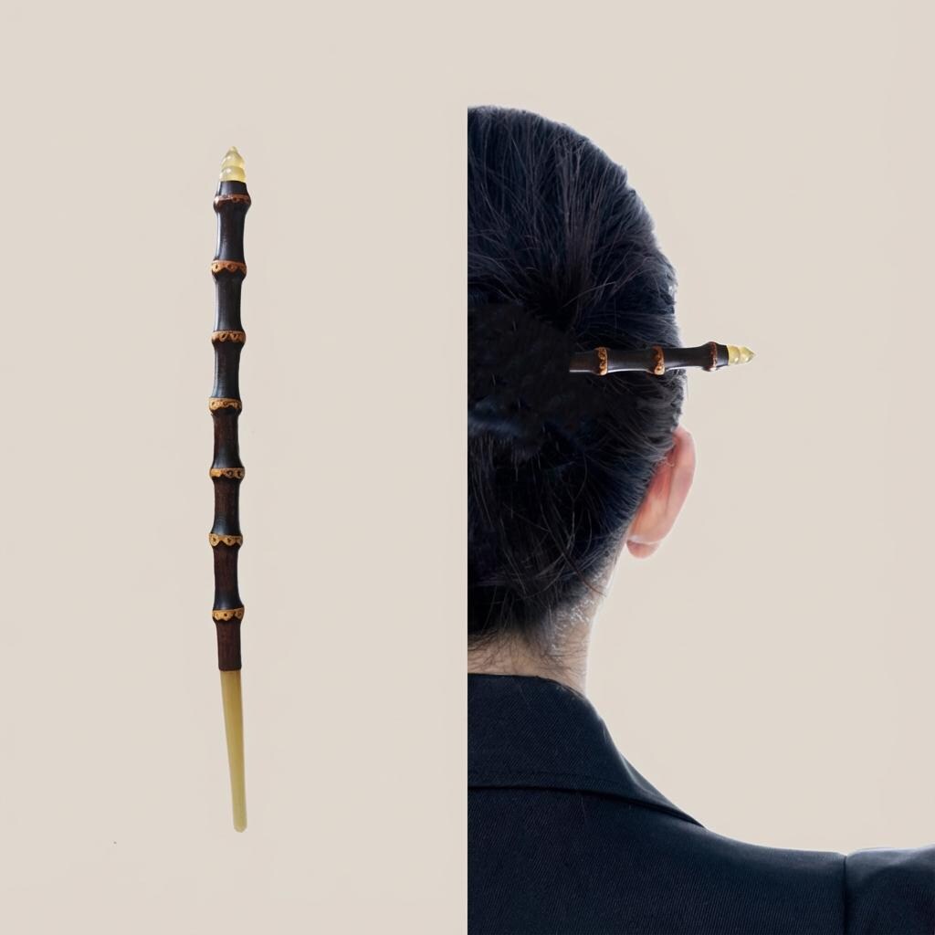 Traditional hairpin with gold accents held by a person with styled hair against a neutral background
