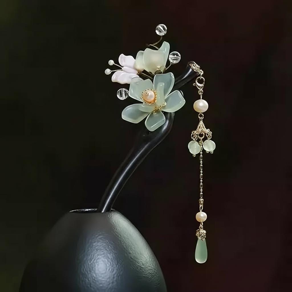 Decorative hairpin with floral design and beads on a dark background