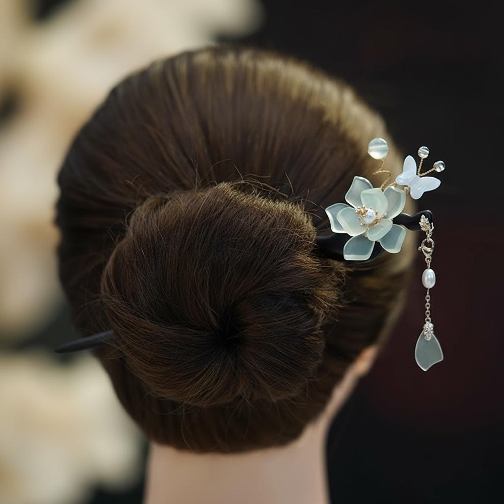 Hair bun with decorative hairpin featuring flowers and butterflies on a blurred background