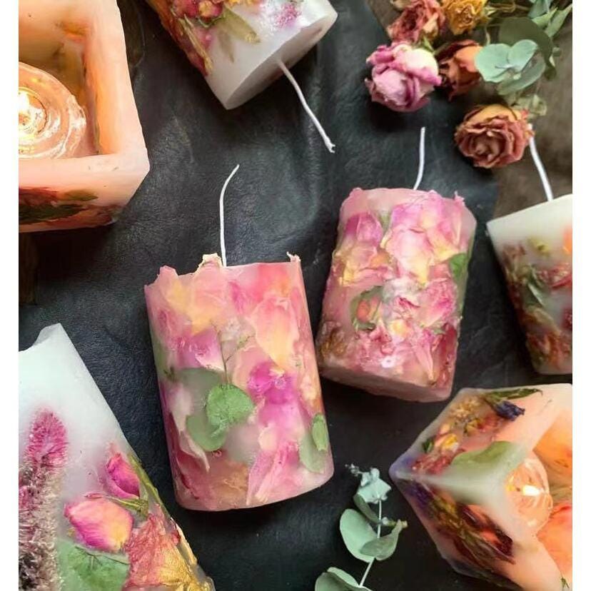 Decorative candles with floral elements on a dark surface