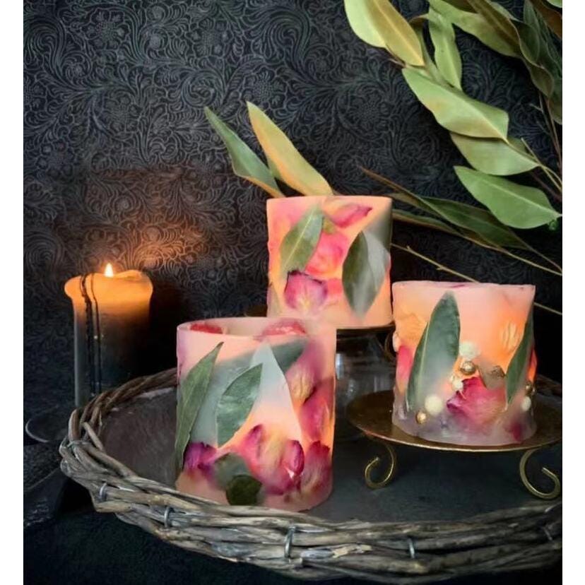 Decorative candles with floral design on a dark textured background