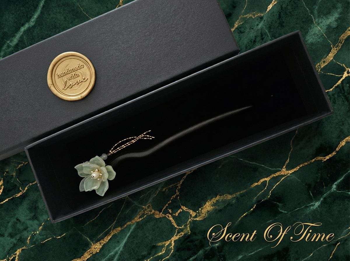 Decorative hairpin in a black box with a gold seal on a green marble background