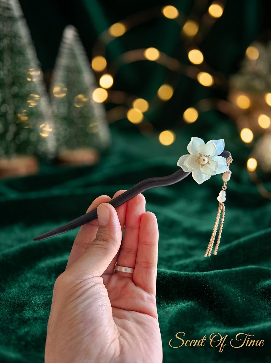 Hand holding a decorative hairpin with a flower design against a festive background.