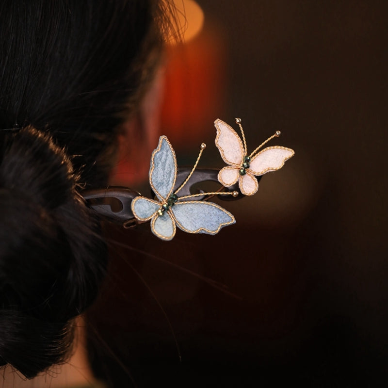 Model wearing butterfly hair pins in a traditional Qipao hairstyle