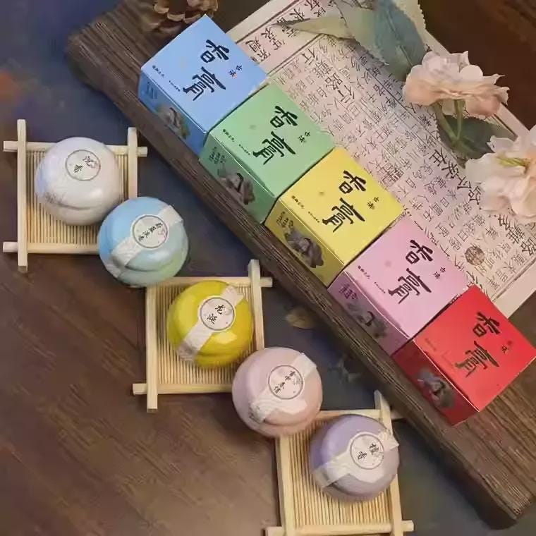 Colorful boxes and spherical items on a wooden surface with text and floral elements.