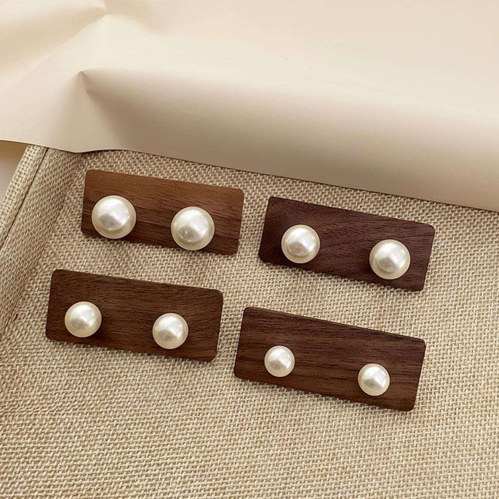 Set of wooden buttons with pearl beads on a textured fabric background