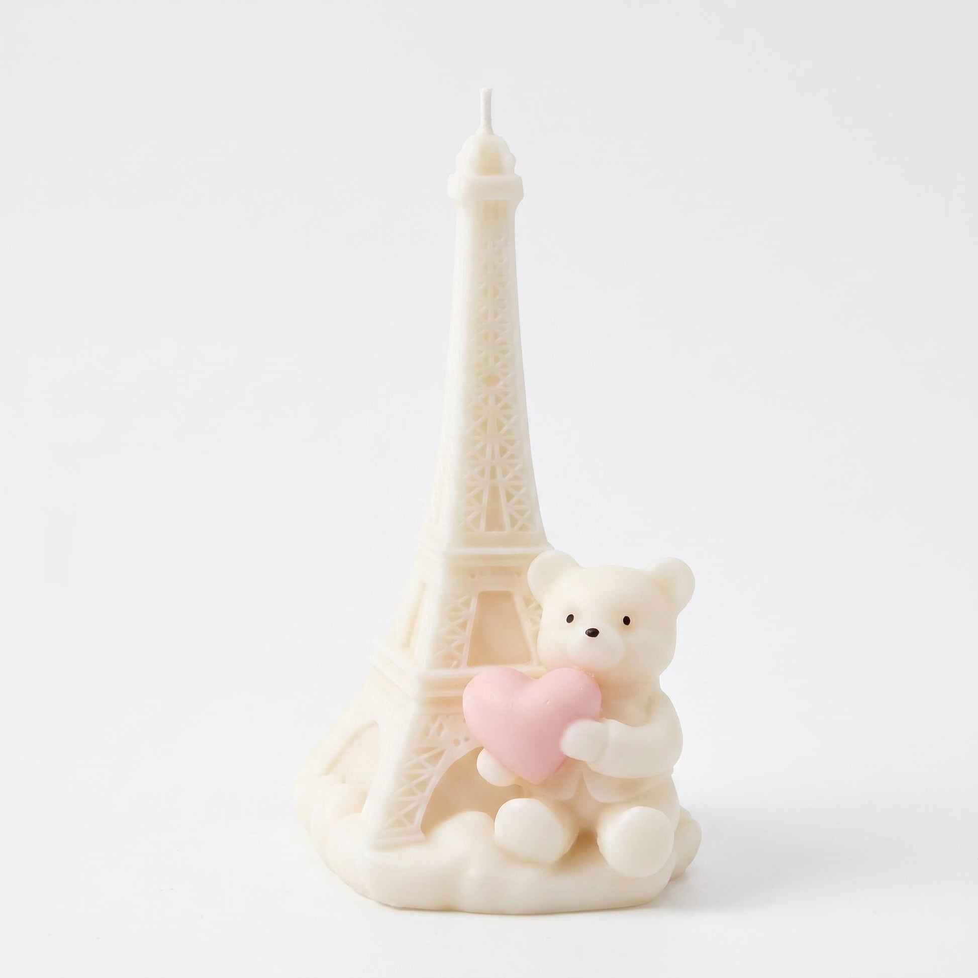 Decorative item with a miniature Eiffel Tower and teddy bear holding a heart on a white background
