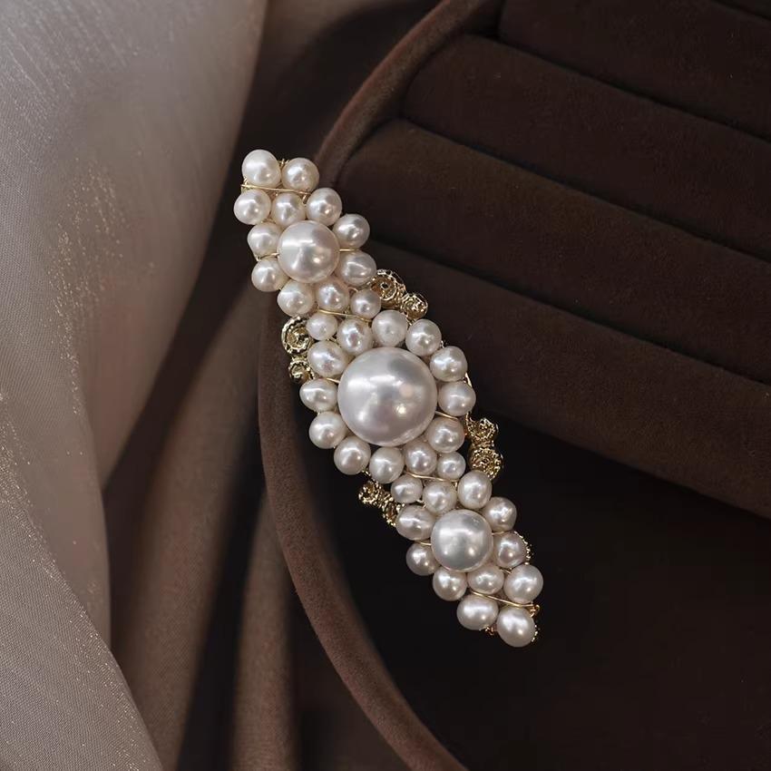 Pearl hair clip on a brown fabric background