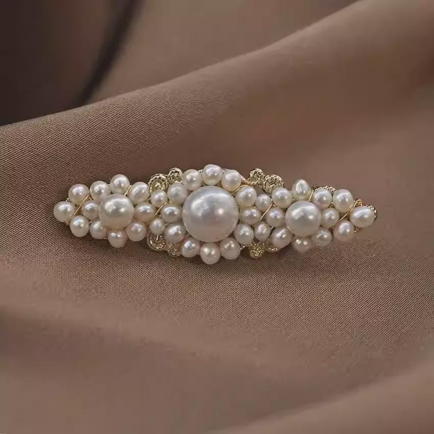 Pearl hair clip on a brown fabric background