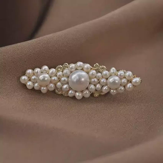 Pearl hair clip on a brown fabric background
