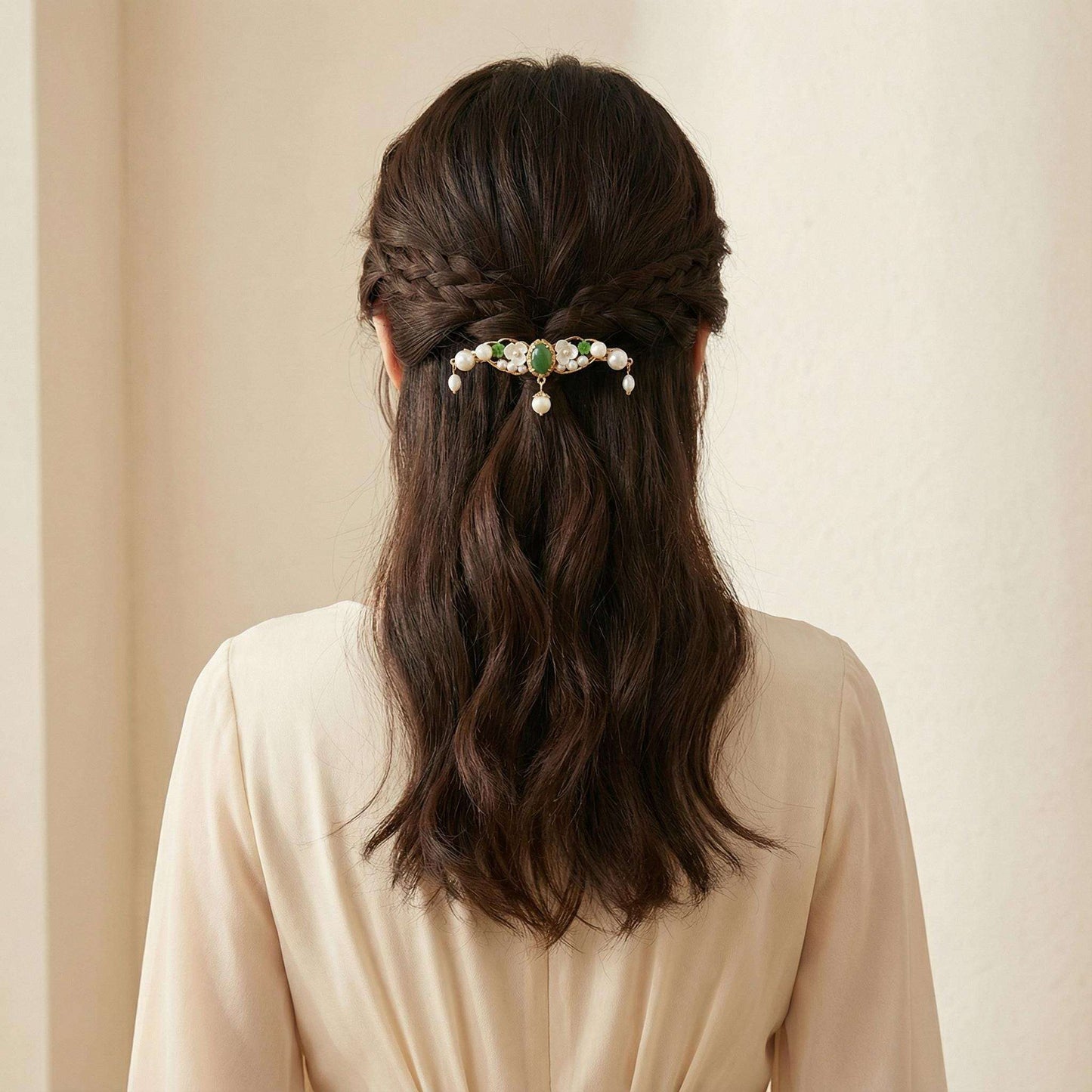 Person with braided hair wearing a decorative hair clip against a beige background