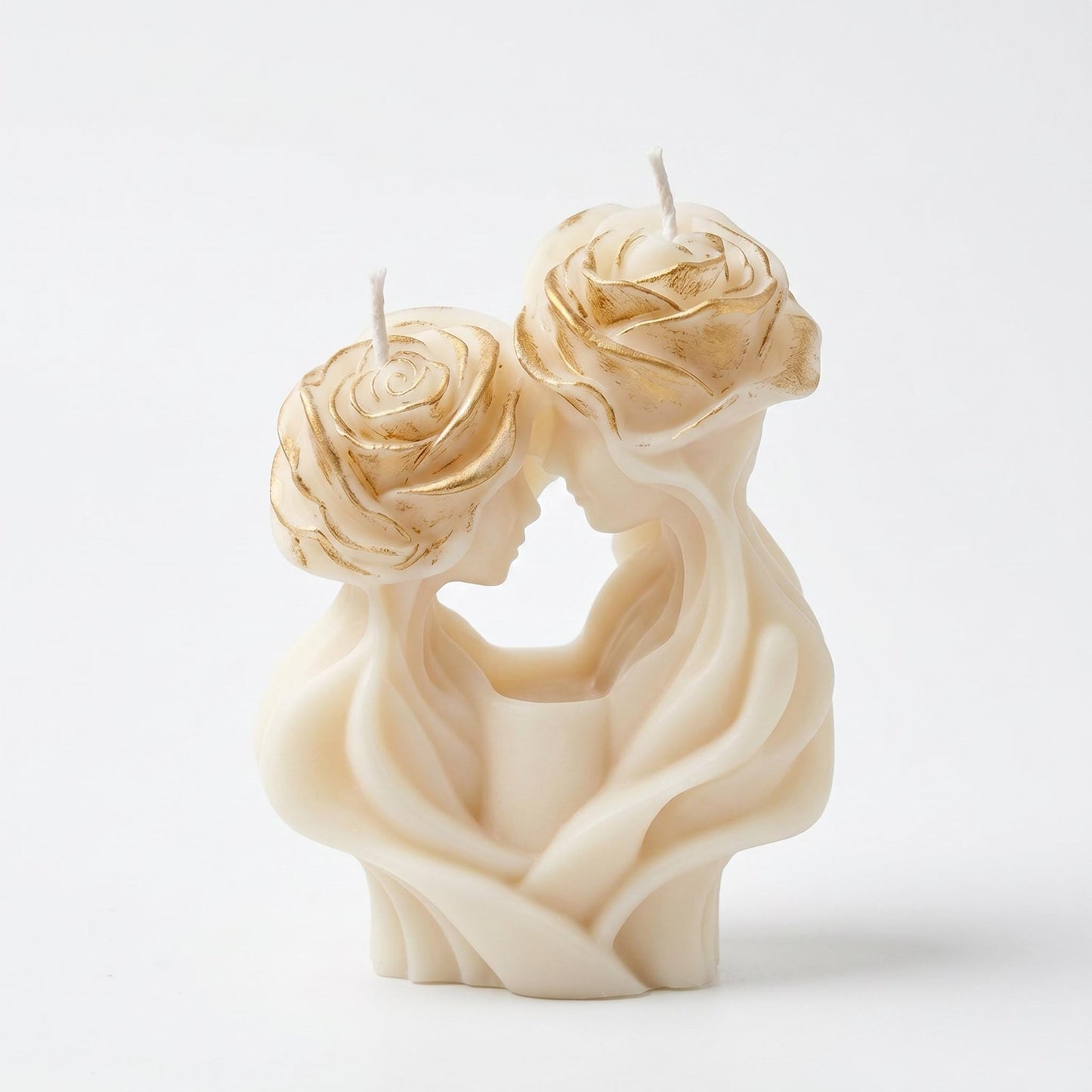 Candle sculpture of two faces with floral designs on a white background
