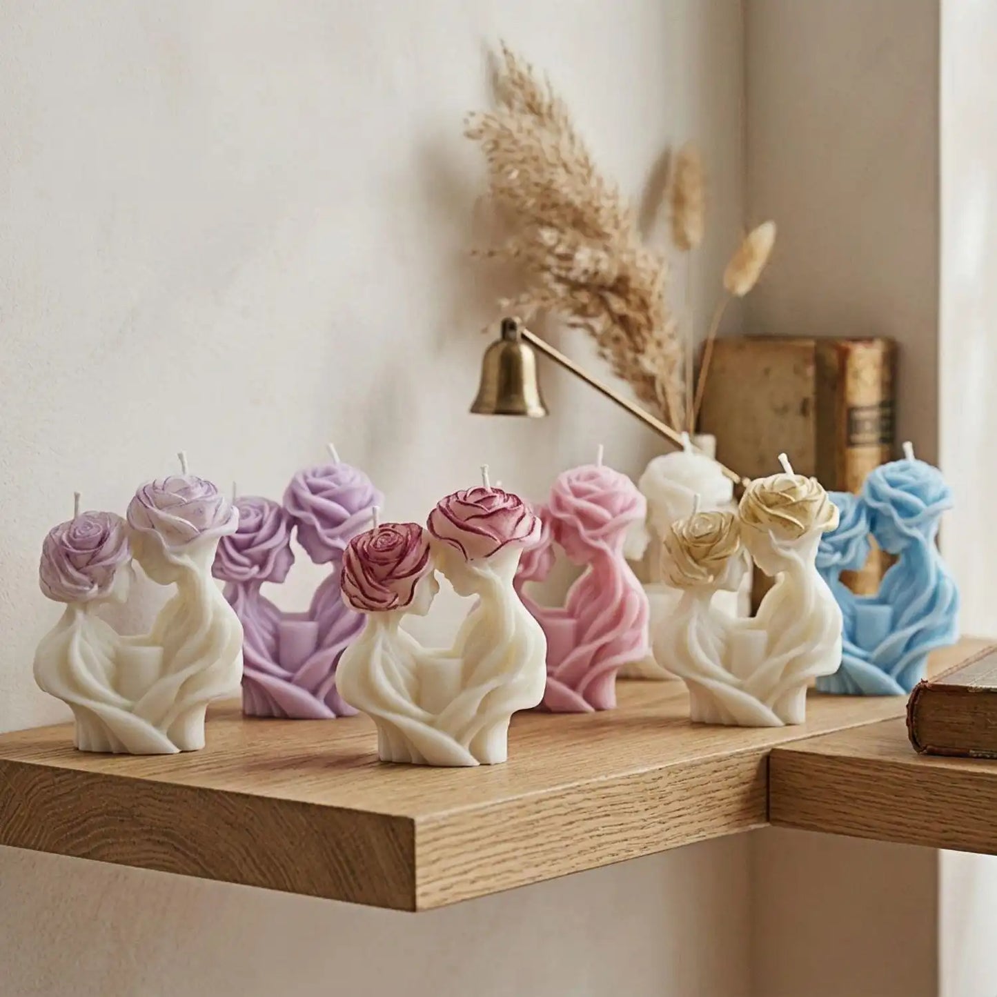 Decorative candles with floral designs on a wooden shelf.