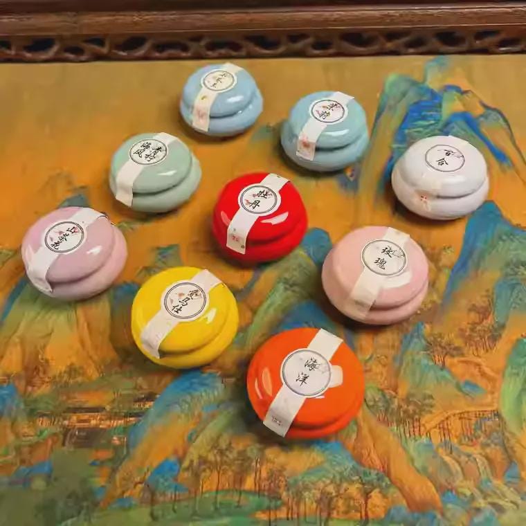 Set of small round balm containers with lids on a decorative surface