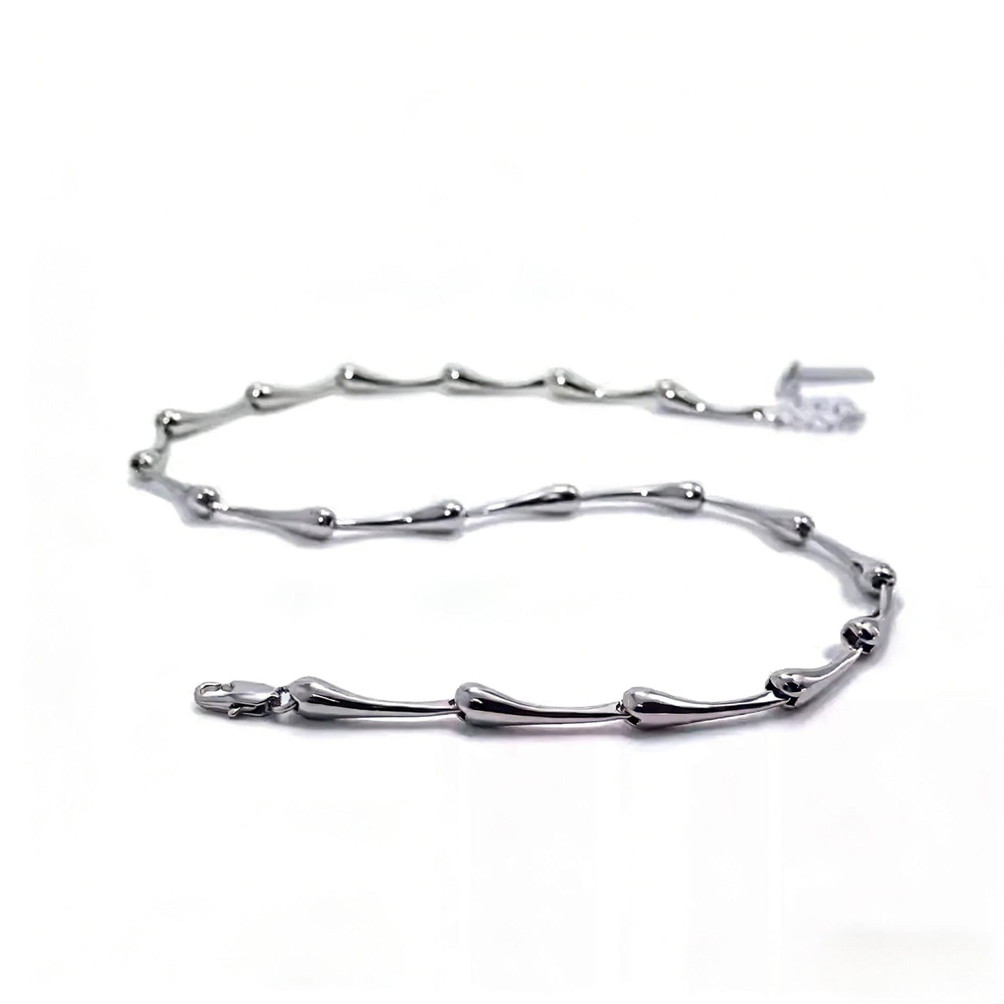 Silver bracelet with branch-like design on a white background