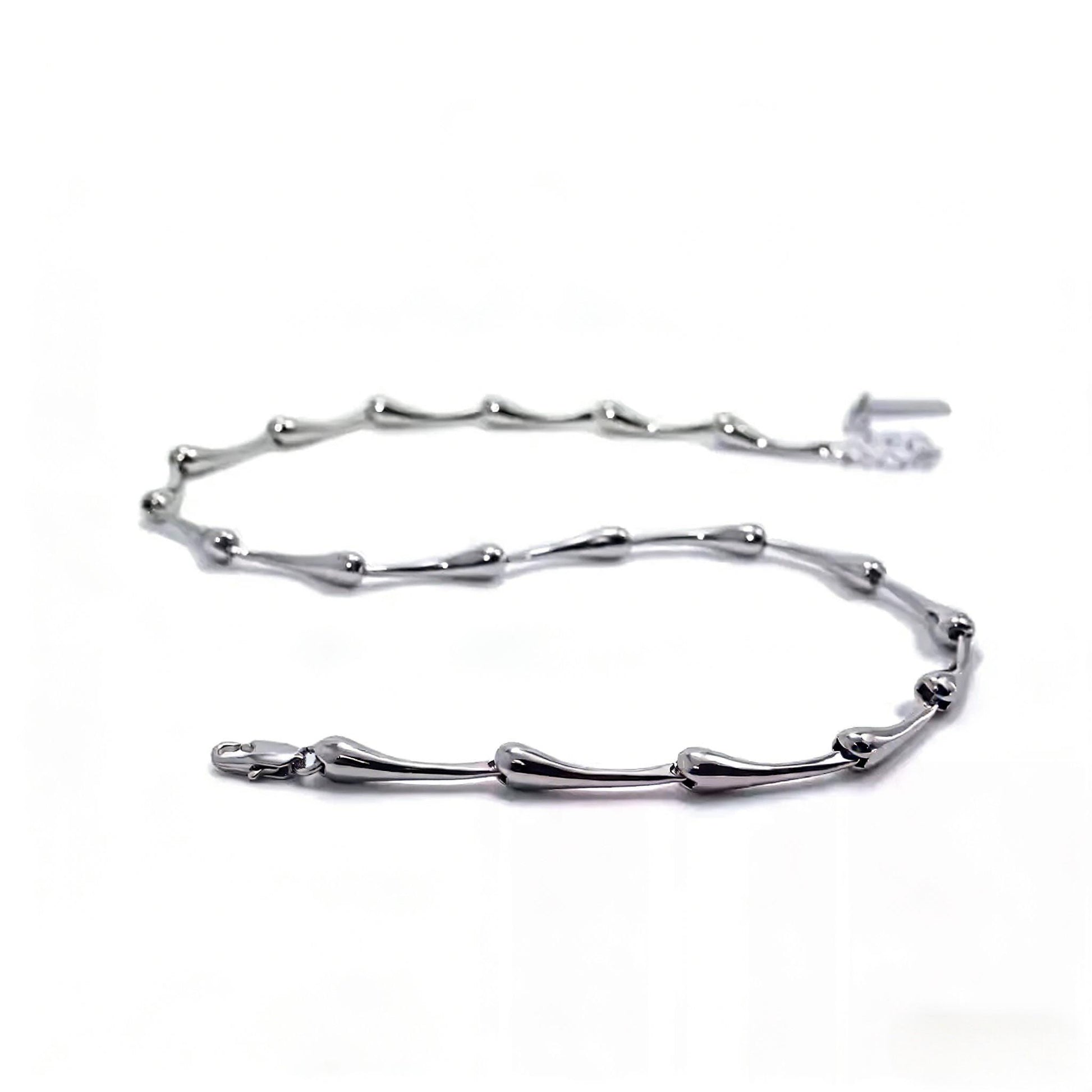 Silver bracelet with branch-like design on a white background
